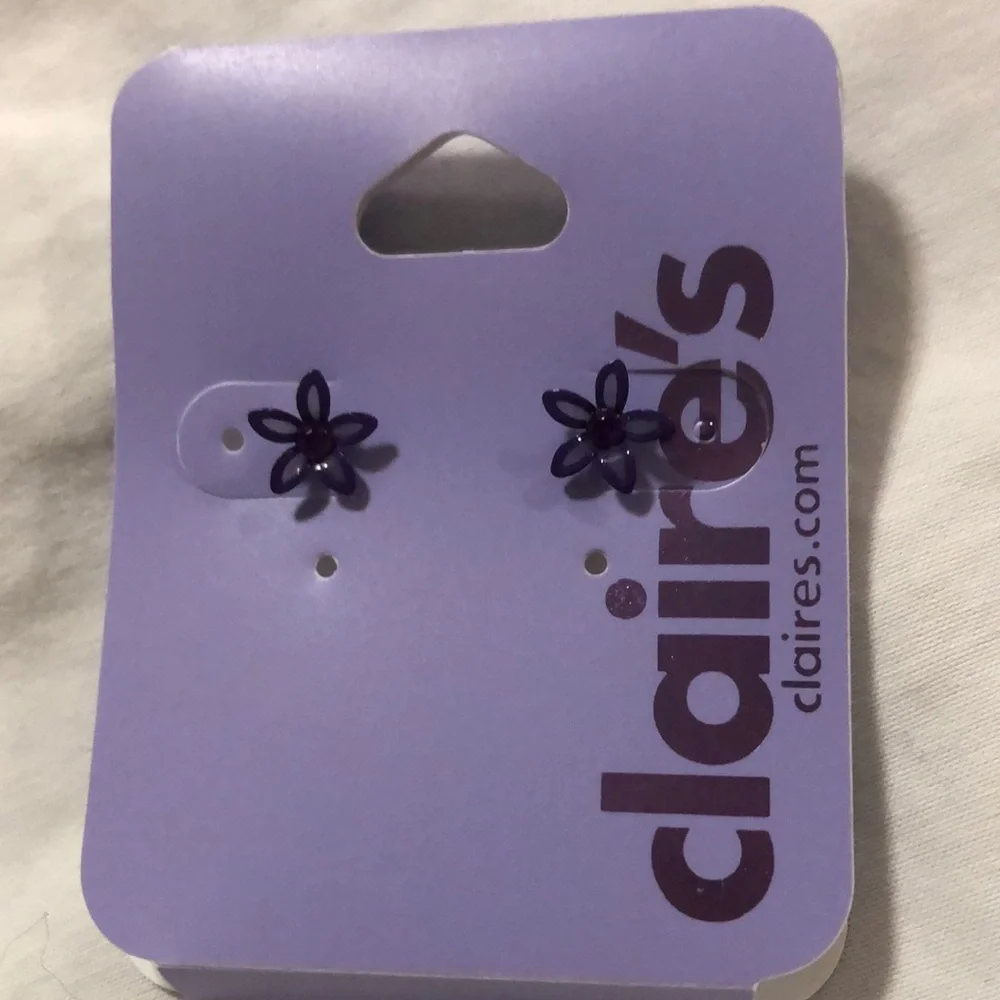 Claire’s purple flower earrings. They measure 1/4 inch each. New never worn.